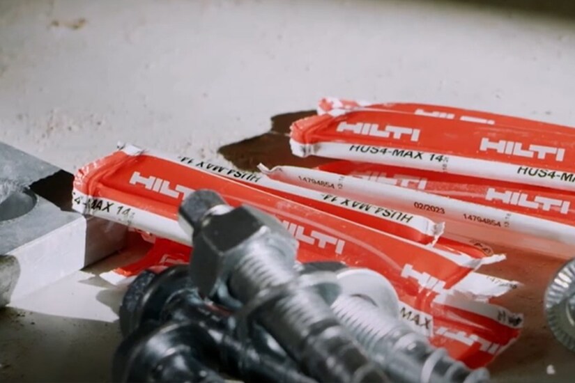 A worker attaches a formwork support with a concrete screw