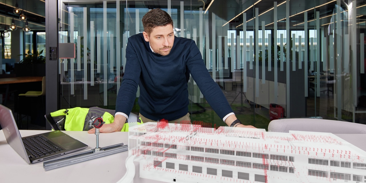 Ingenieur op locatie om een BIM 3D-constructiemodel te bekijken met alle berekende beugels en modulaire systemen