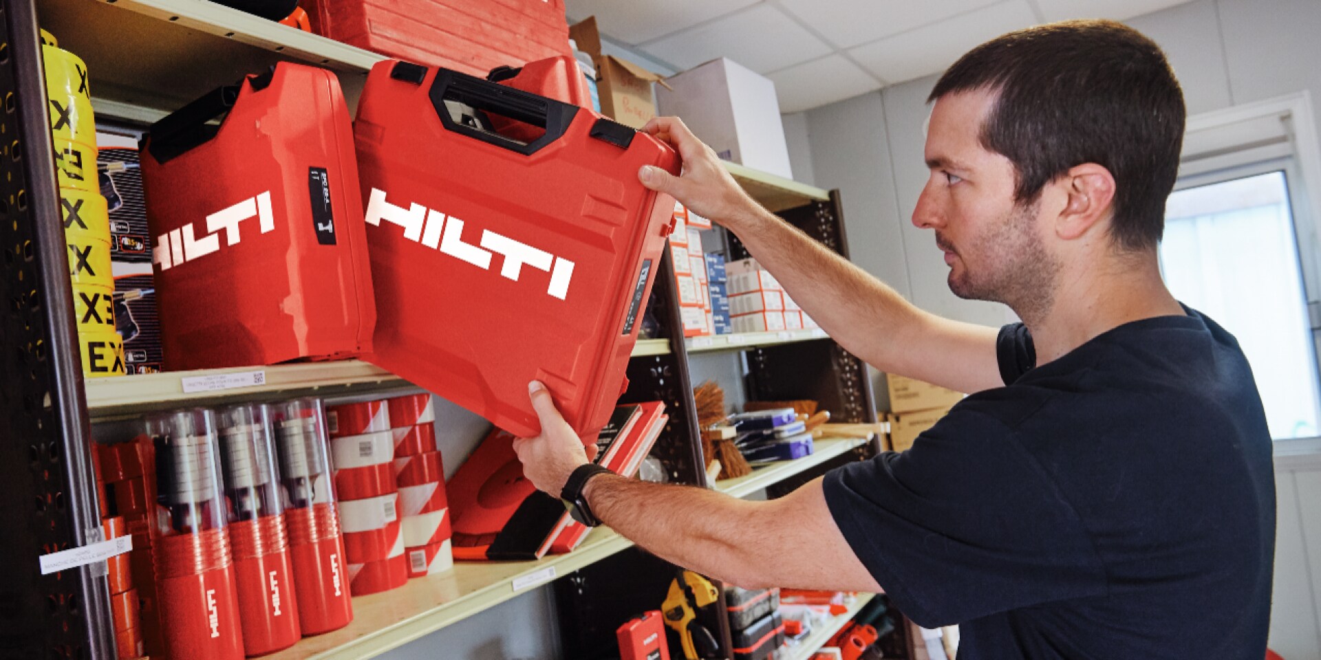 Een persoon schuift een Hilti-koffer op een plank.